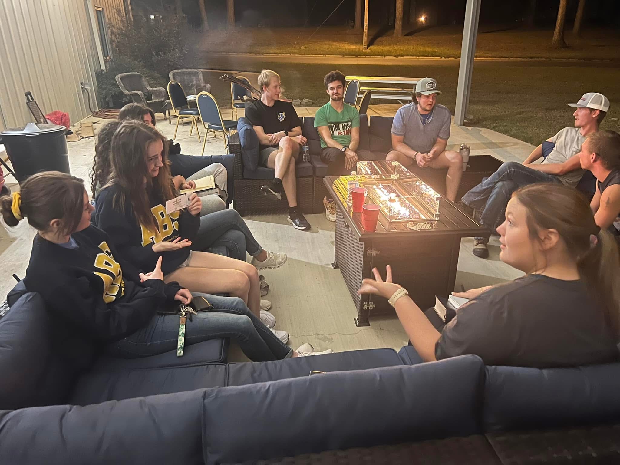 Students enjoying community time around a fire pit